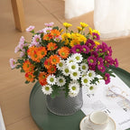 Bouquet of colorful flowers in a vase on a table with a cup and saucer.