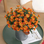 Bouquet of orange flowers in a decorative pot on a green tray with a magazine underneath.