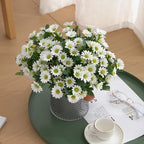 Bouquet of white flowers in a clear vase on a green tray with a cup and saucer.