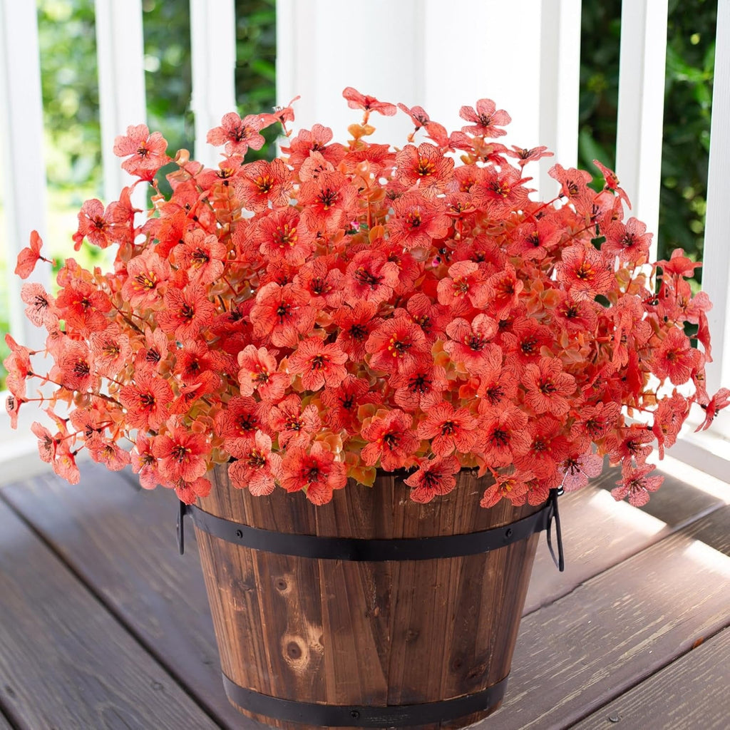 Potted plant with coral-colored flowers on a wooden deck