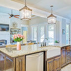 Modern kitchen with wooden cabinets, marble countertops, and a vase of pink tulips.