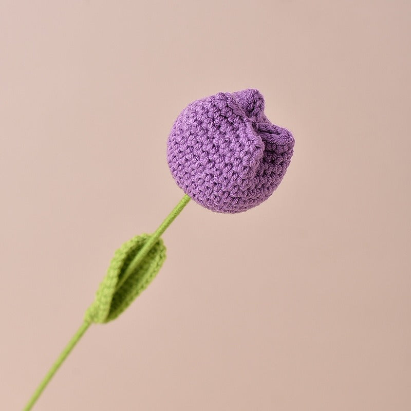 Knitted purple flower on a beige background