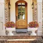 Wooden front door with floral planters on a brick porch