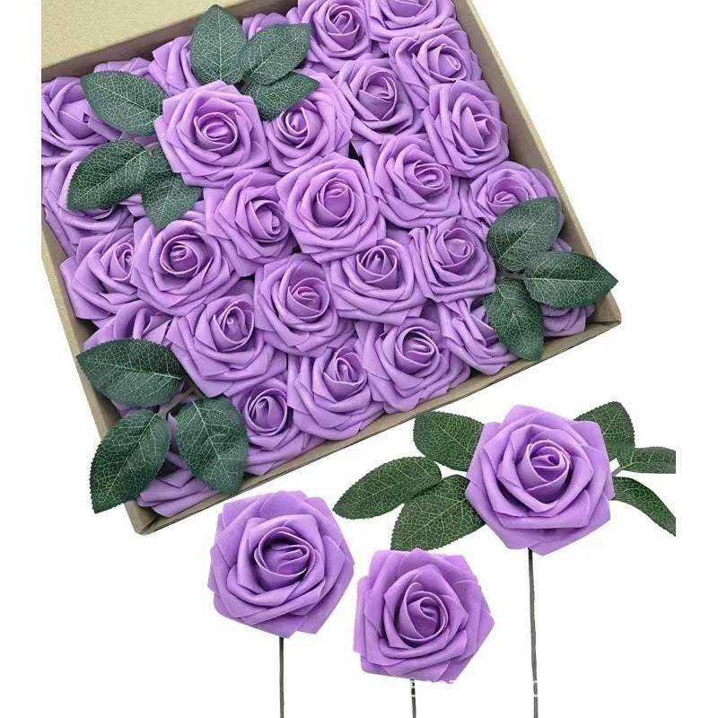 Box of purple foam roses with green leaves on a white background