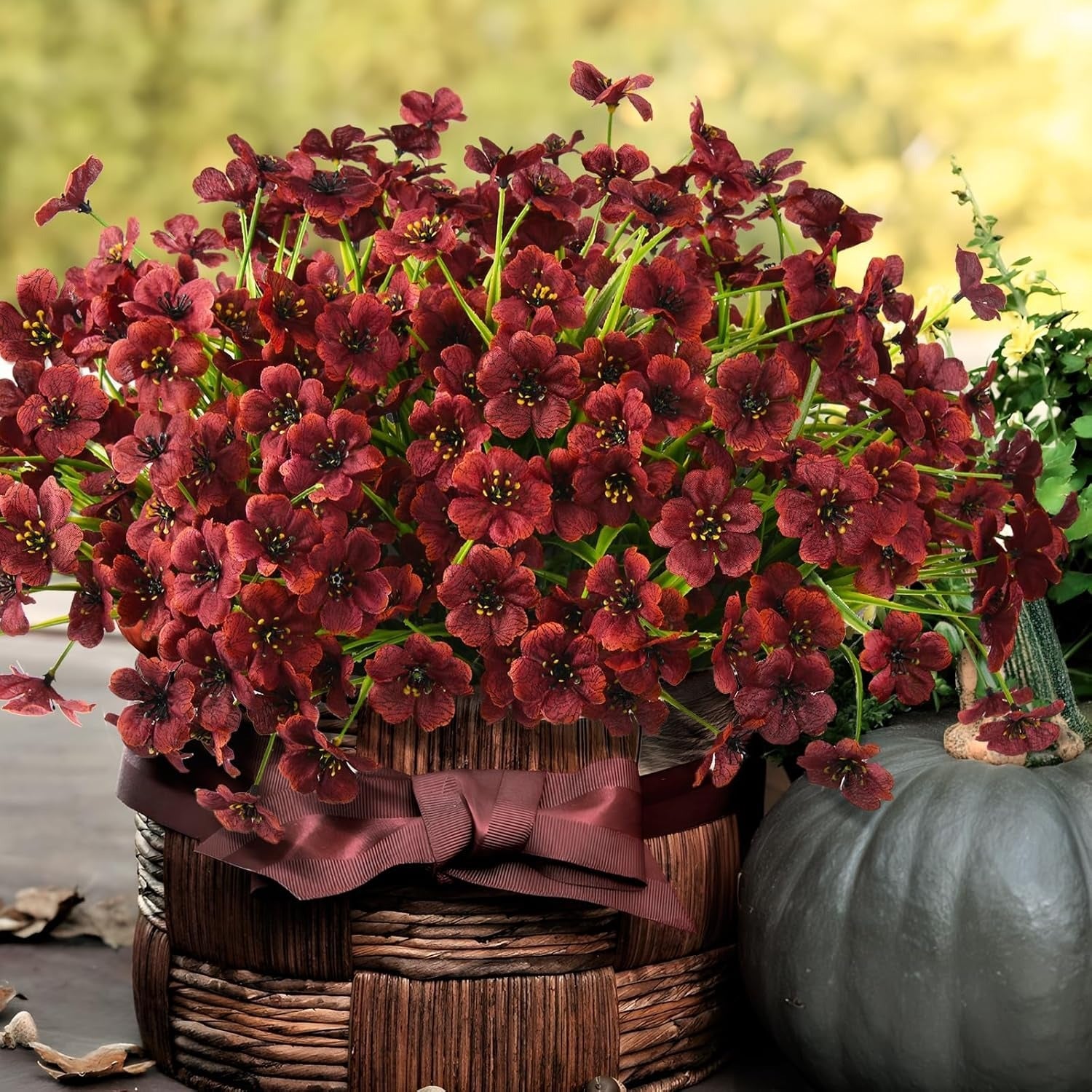Basket of red flowers with a pumpkin in the background