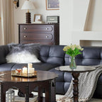Living room with dark leather sofa, wooden coffee table, and decorative items.