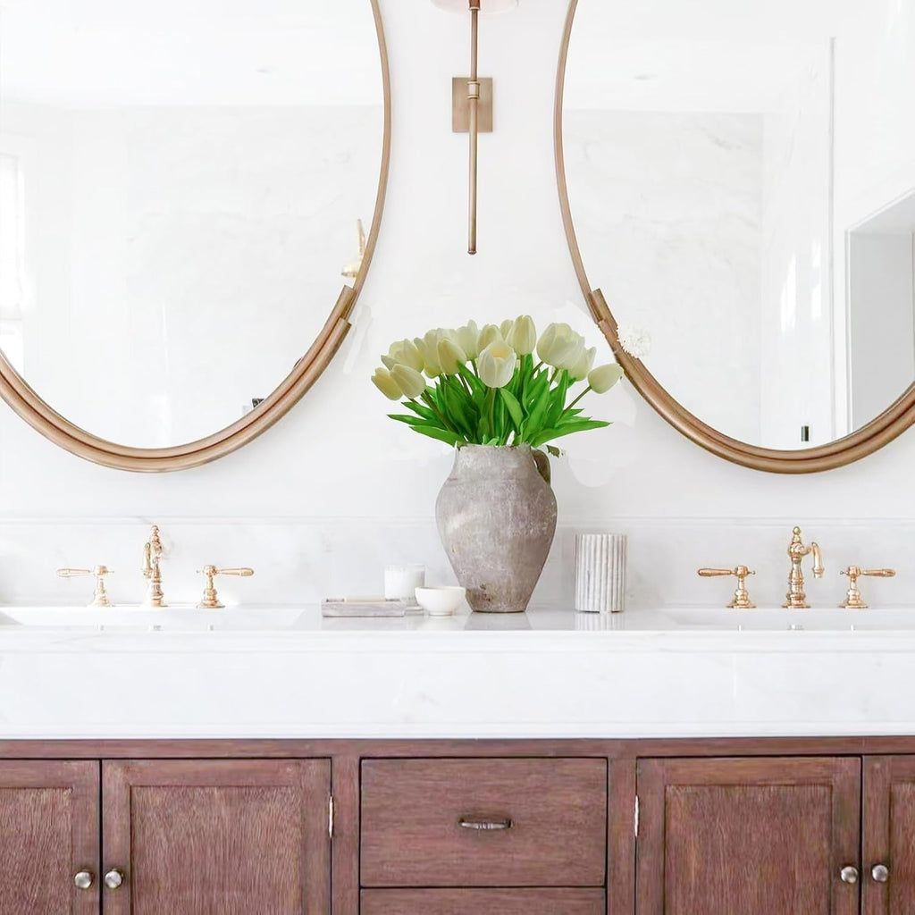 Bathroom vanity with wooden cabinets, white countertop, and gold fixtures.