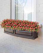 Window box with red flowers on a white brick wall
