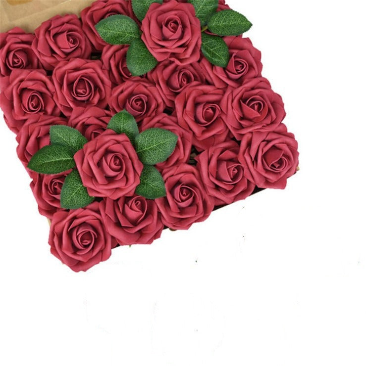 Heart-shaped arrangement of red roses with green leaves on a white background