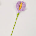 Crocheted flower with purple petals and yellow center on a white background
