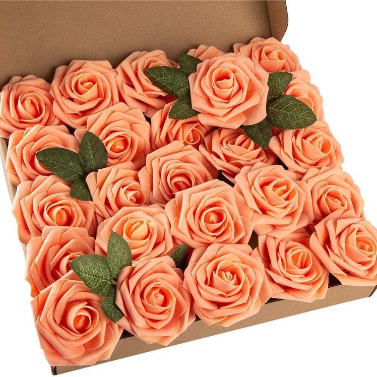 Box of peach-colored roses with green leaves on a white background