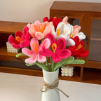 Knitted flowers in a vase on a wooden shelf