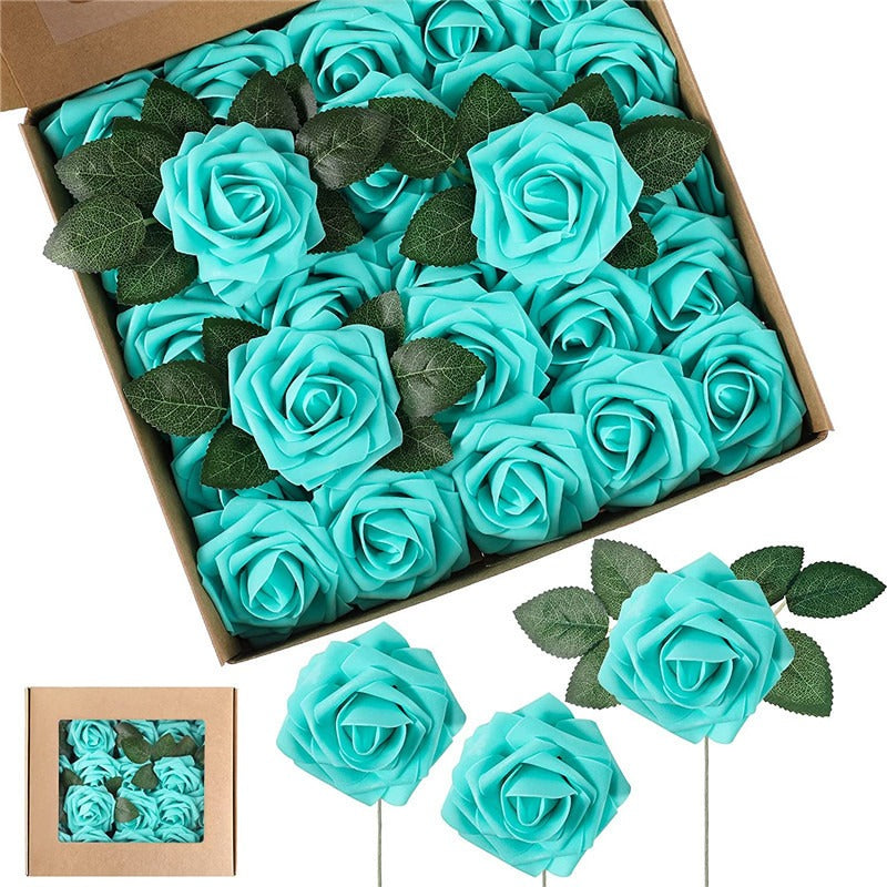 Box of turquoise artificial roses with green leaves, some on sticks.