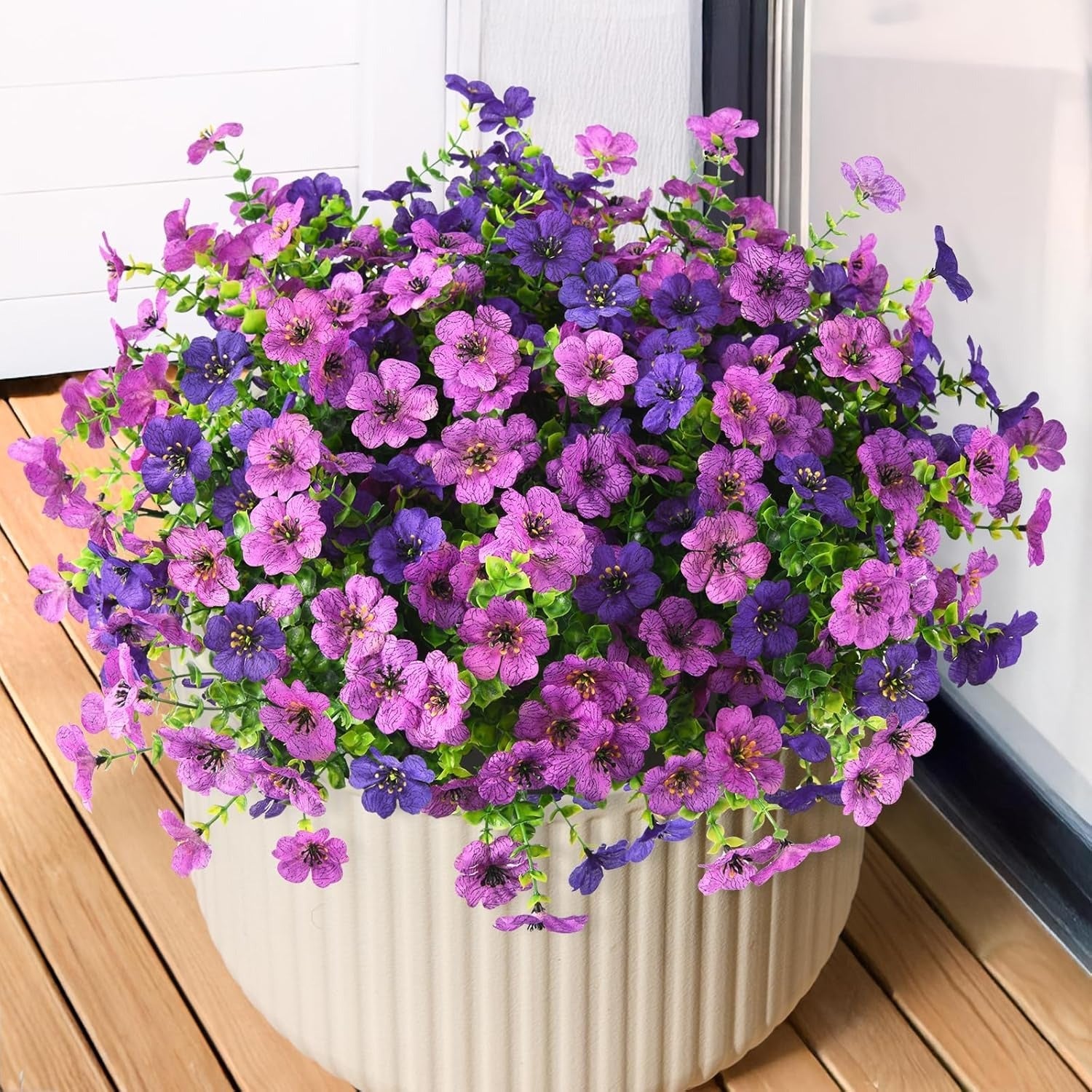 Potted plant with purple and pink flowers on a wooden surface