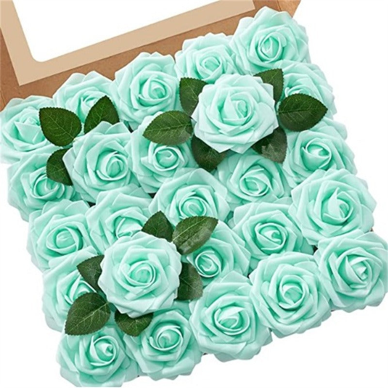 Turquoise artificial roses with green leaves in a cardboard box on a white background