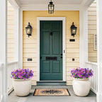 Front door of a house with two potted plants and a welcome mat.