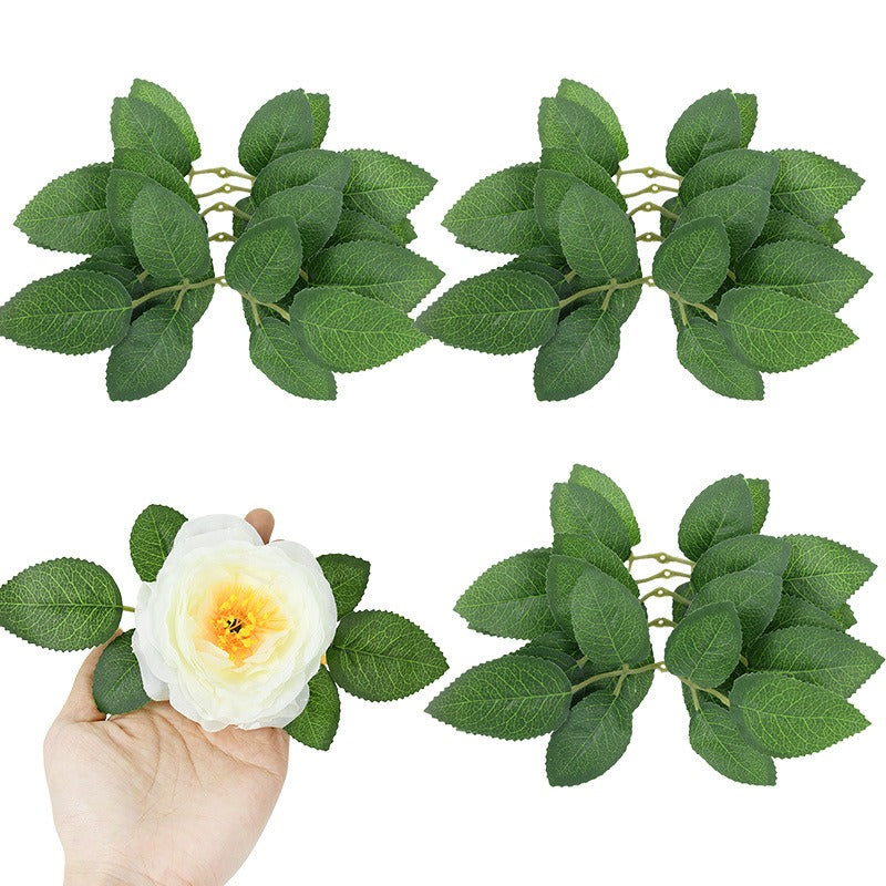 Set of artificial green leaves with a hand holding a white flower on a white background