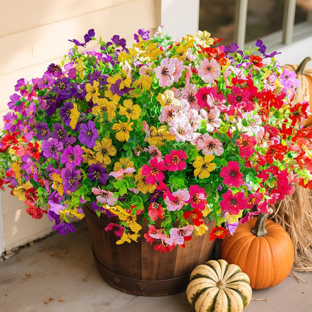 Colorful potted flowers with pumpkins on a neutral background