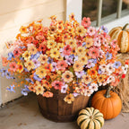 Bouquet of colorful flowers in a wooden basket with pumpkins on a porch.