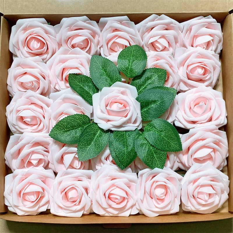 Box of pink artificial roses with green leaves