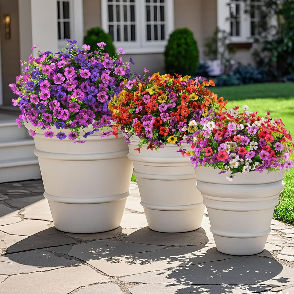 Three flower pots with colorful flowers on a patio