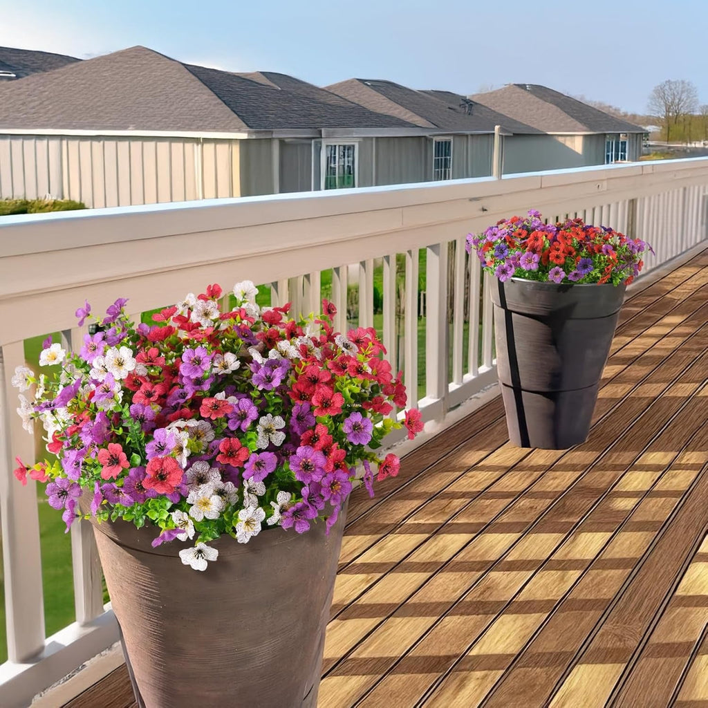Two flower pots with colorful flowers on a wooden deck.