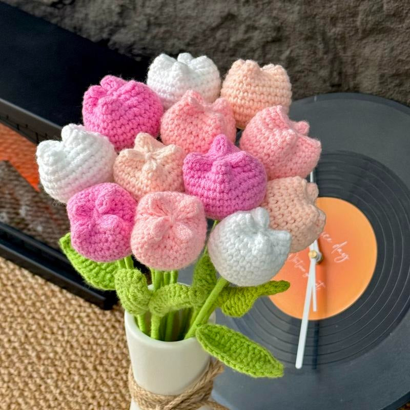 Crocheted tulip flowers in pink, white, and green on a vinyl record.