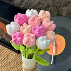 Crocheted tulip flowers in pink, white, and green on a vinyl record.