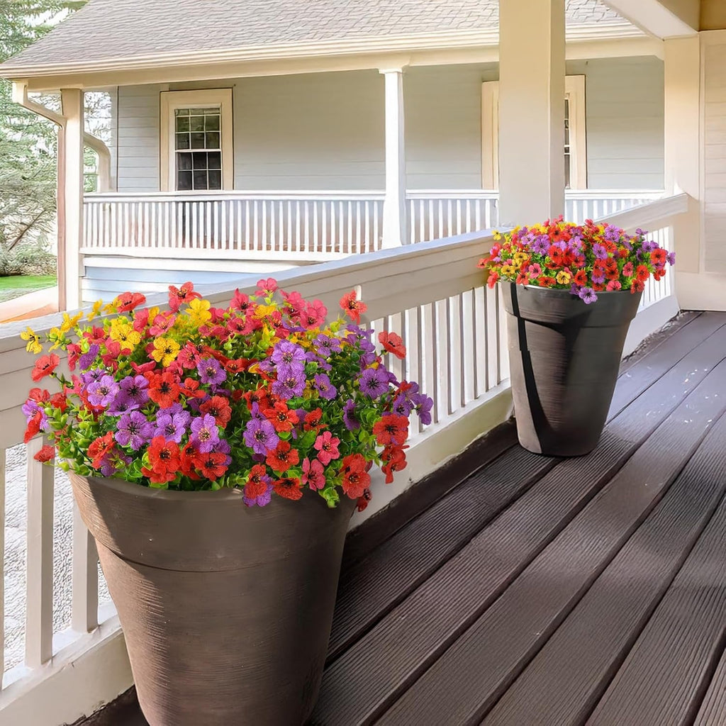 Two flower pots with colorful flowers on a wooden deck.