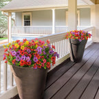 Two flower pots with colorful flowers on a wooden deck.
