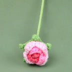 Crocheted pink rose on a green background