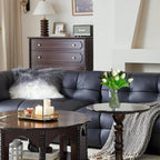 Living room with dark leather sofa, wooden coffee table, and decorative items.