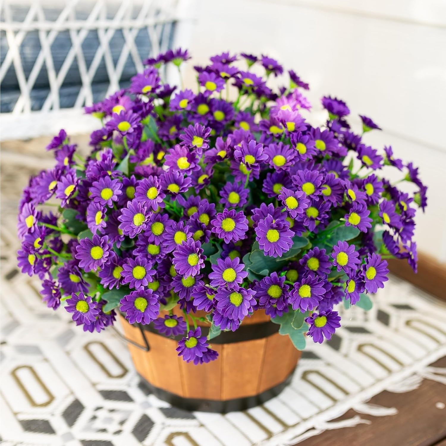 Potted plant with purple flowers and yellow centers on a white surface