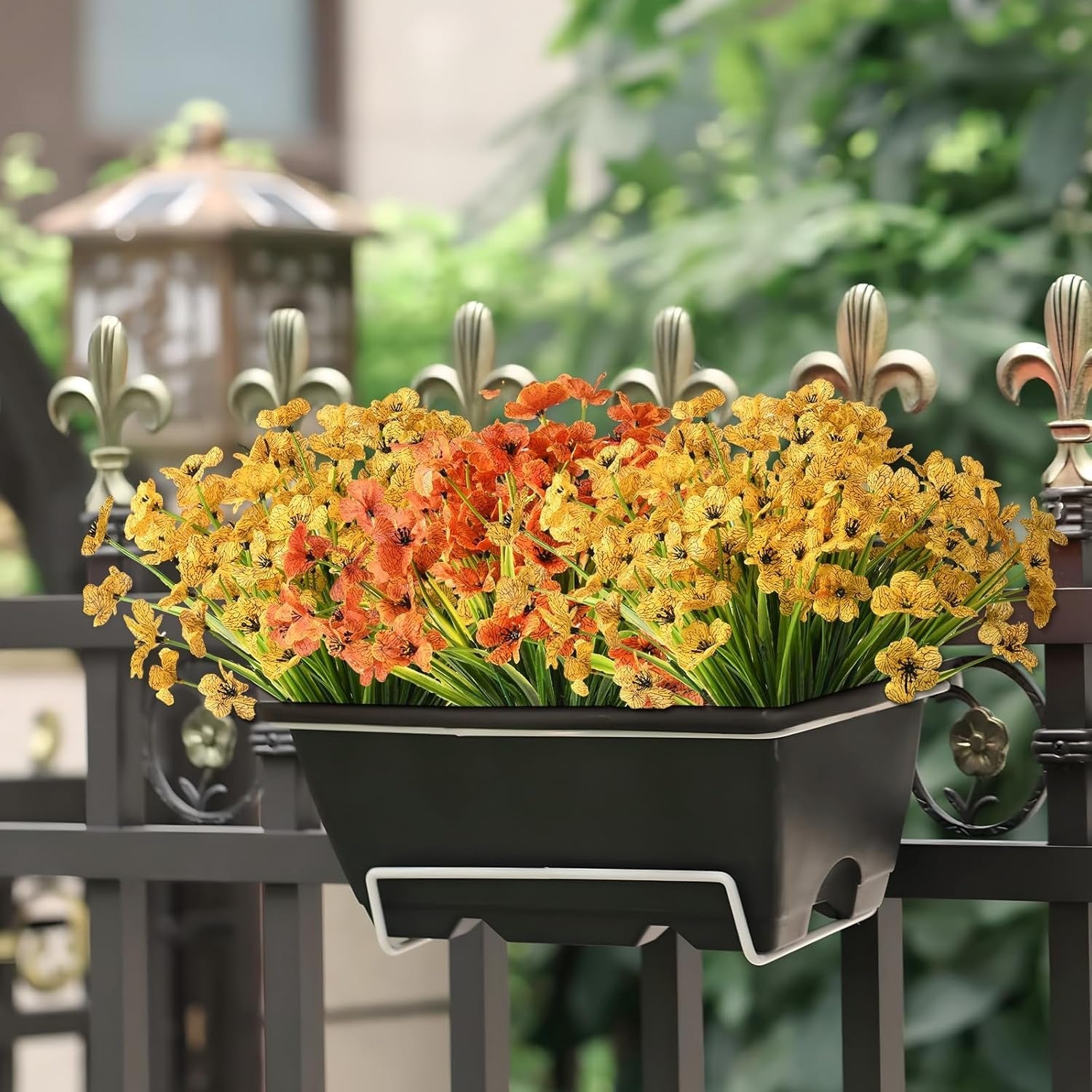 Floral planter hanging on a metal railing with a blurred garden background