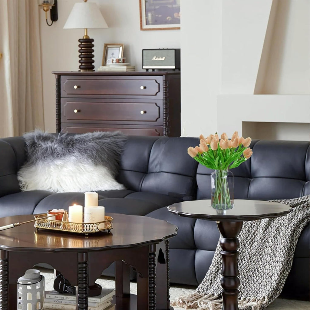 Living room with a dark leather sofa, wooden coffee table, and decorative items.