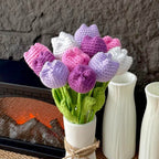 Bouquet of crocheted tulips in a white vase with a textured wall background