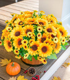 Bouquet of yellow sunflowers in a wooden basket on a wooden surface with a pumpkin and pinecones.