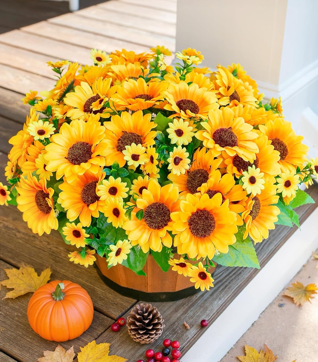Bouquet of yellow sunflowers in a wooden basket on a wooden surface with a pumpkin and pinecones.