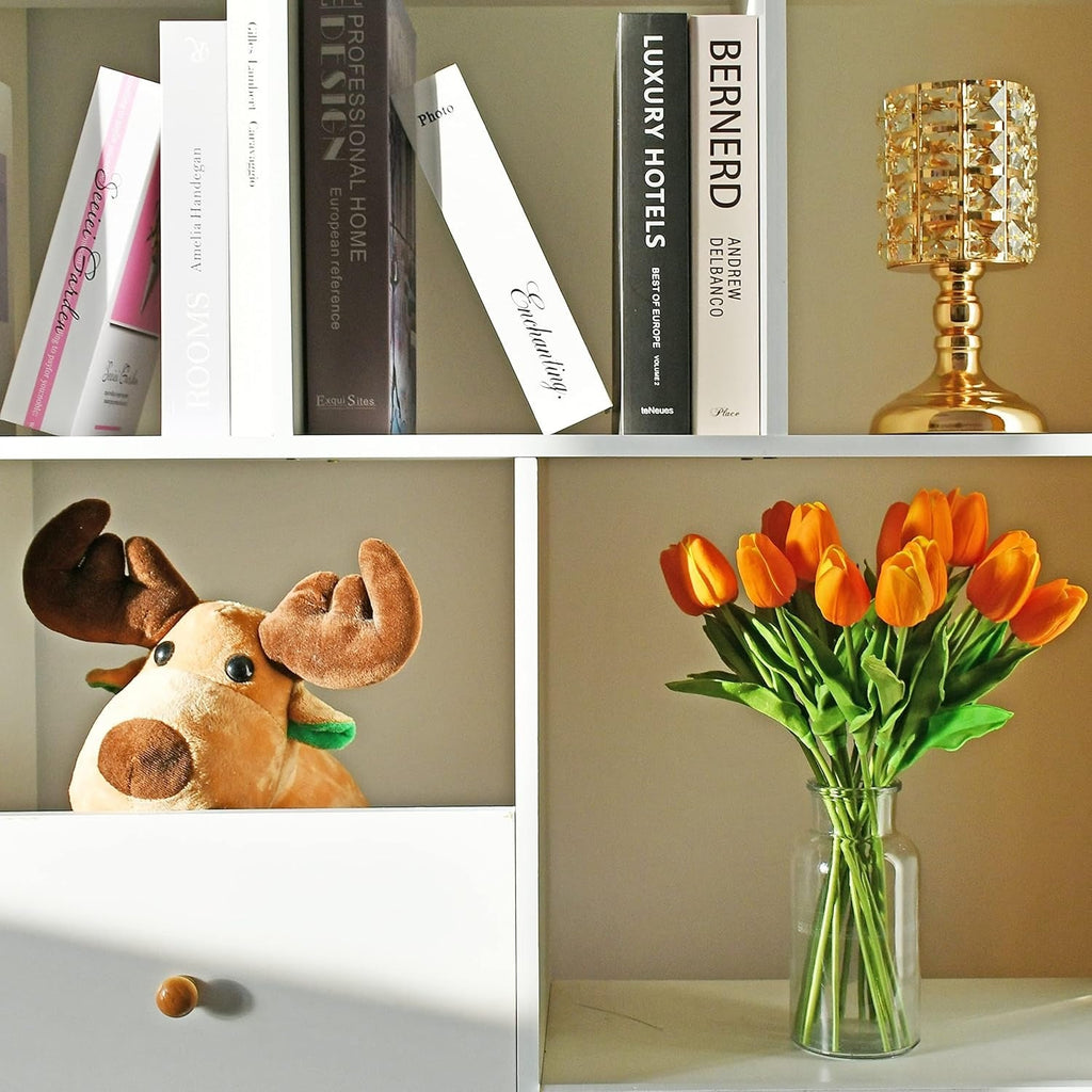 Collage of a plush moose, books, a gold lamp, and a vase with orange tulips on a shelf.
