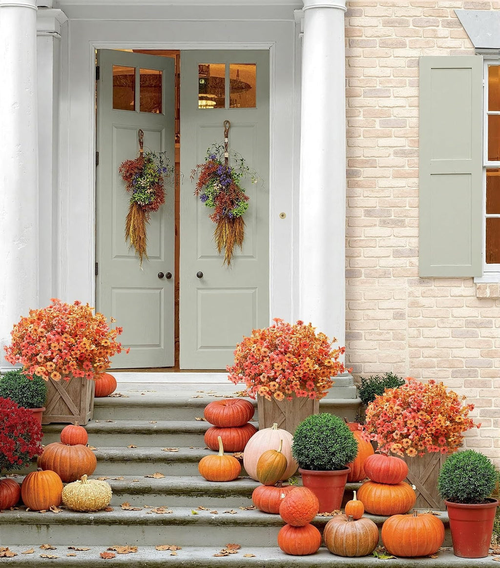 Decorative autumn scene with pumpkins and flowers on a front porch.