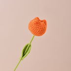 Knitted orange tulip with green stem on a beige background