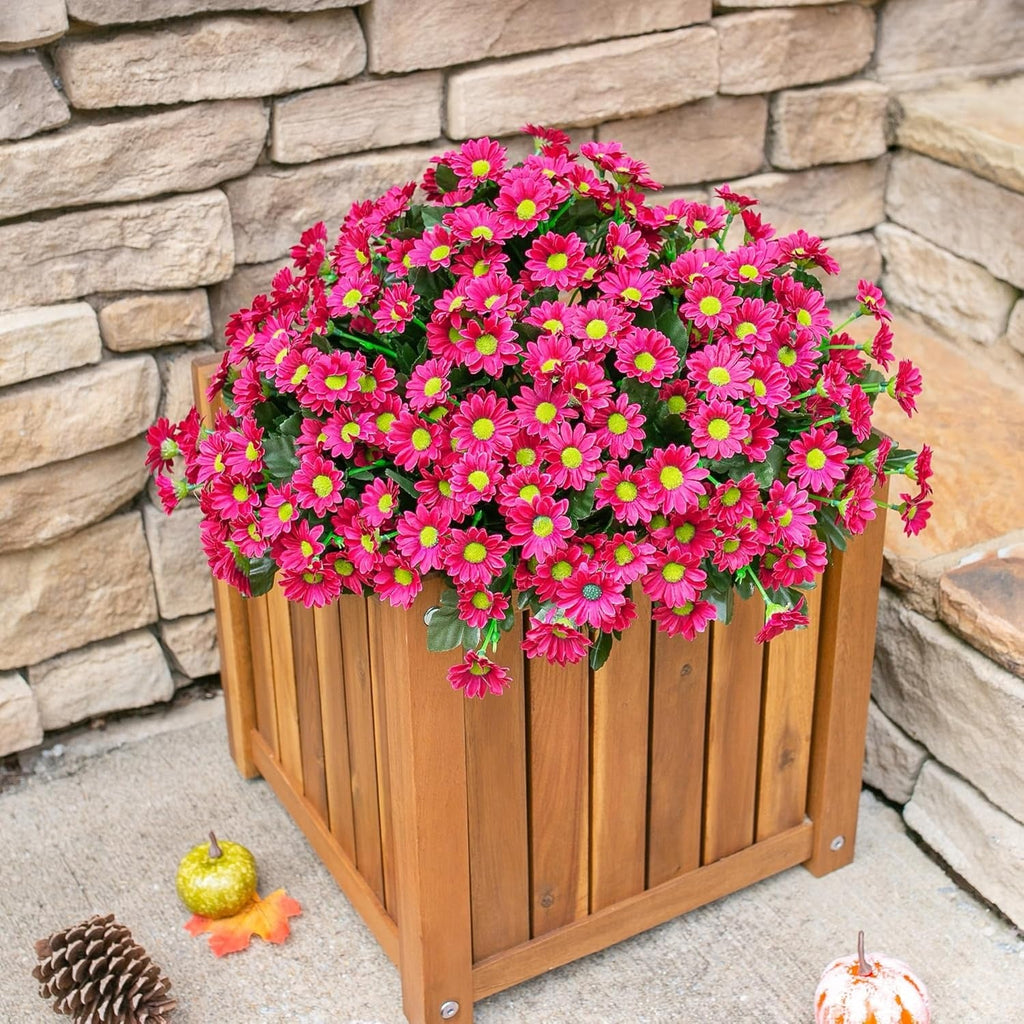 Wooden planter with pink flowers against a stone wall