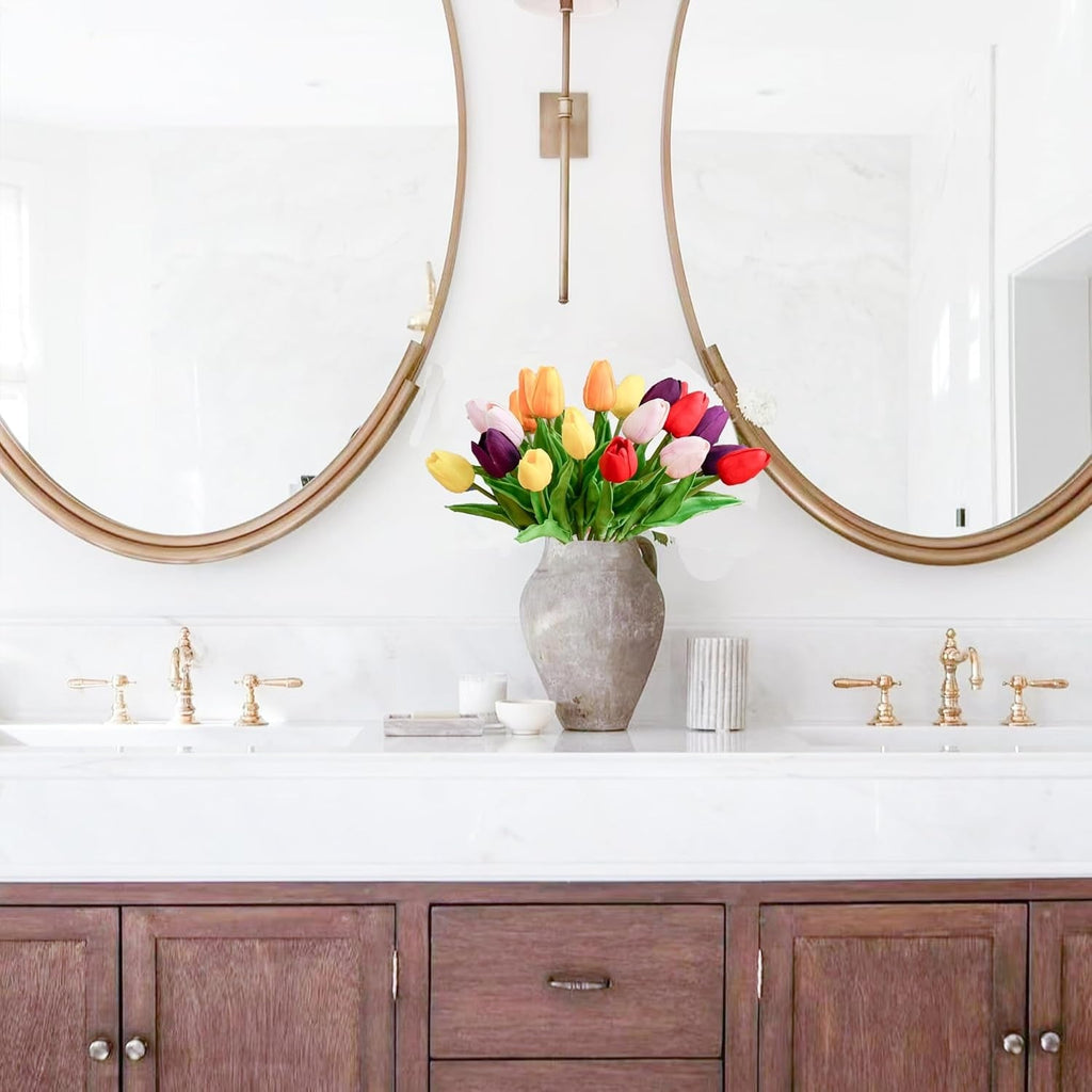 Bathroom vanity with wooden cabinets, white countertop, and colorful tulips in a vase.