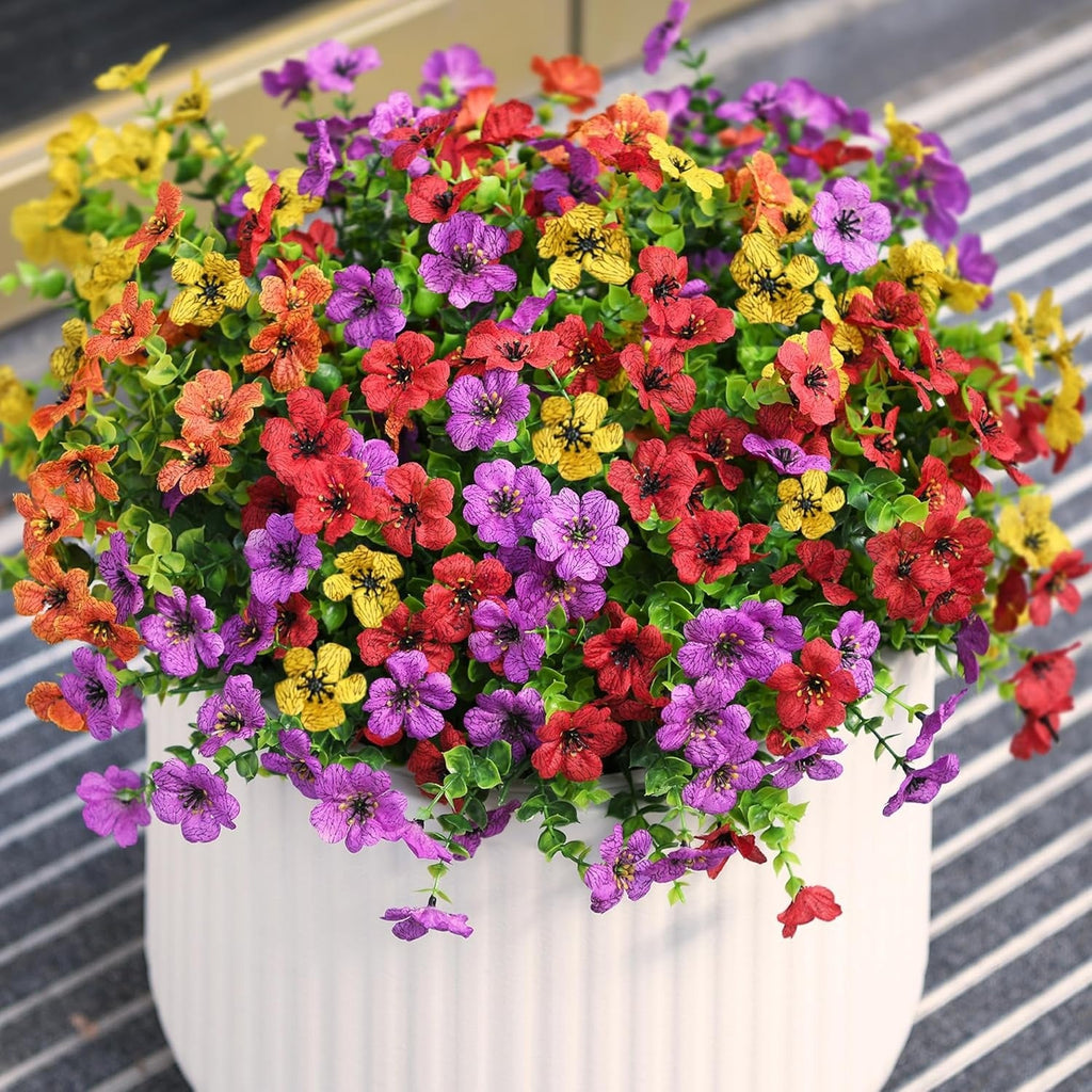 Colorful potted flowers with a white pot on a striped background
