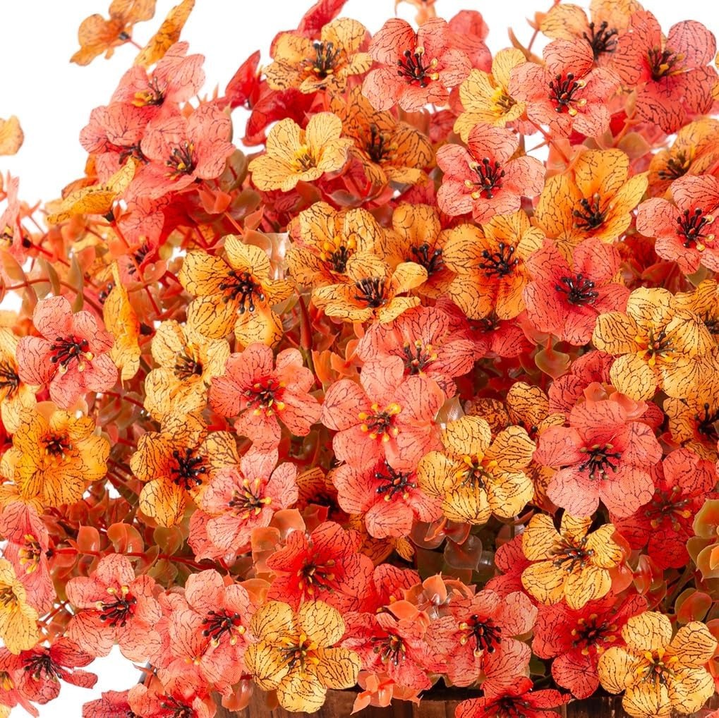Close-up of artificial flowers in pink, orange, and yellow on a white background